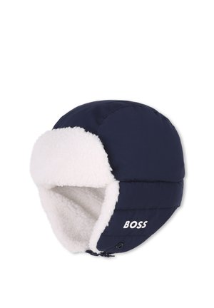 Chapeau trappeur d'hiver bleu marine avec doublure en polaire blanche et rabats d'oreille, avec le mot "BOSS" sur le côté.