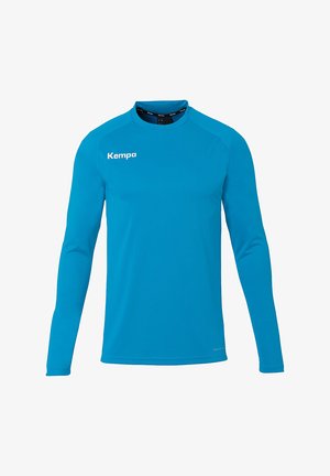 T-shirt de sport à manches longues en tissu bleu lisse, avec un col rond et un logo "Kempa" blanc bien visible à l'avant.
