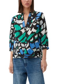 Chemise à motifs noirs, verts et bleus, avec une coupe décontractée, un col en V et des manches trois-quarts, fabriquée en tissu léger.