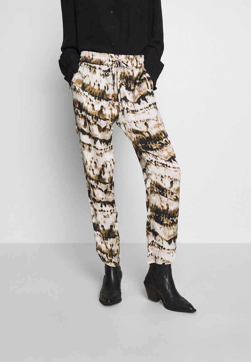 Pantaloni a gamba ampia con un motivo tie-dye bianco, marrone e nero. Vita elastica con cordoncino, gamba affusolata e tessuto leggero.