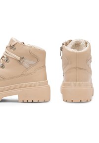 Kohvade ankle saapad, millel on pehme vooder, lame kummist tallad, metalldetailid ja paeltega disain. Omab külgvetti, mis tagab mugava jalgrrikkumise.