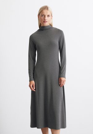 Langermet grå kjole med høy hals. Laget av mykt, elastisk stoff, har den et løst og flytende design uten mønstre eller detaljer.