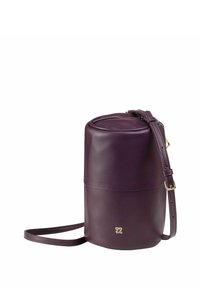 Bolso circular en cuero púrpura profundo con una textura suave. Presenta una correa ajustable y acentos en dorado.