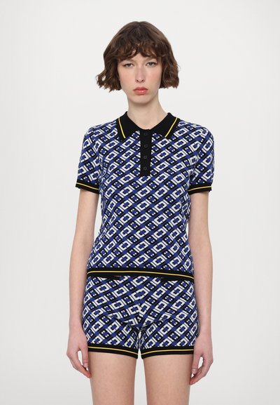 Ensemble de polo et shorts en bleu marine avec un motif en losanges blanc et bleu clair, doté d'un col noir et d'une bordure jaune.