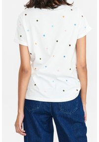 Witte t-shirt met korte mouwen en kleurrijke stippen in groen, blauw, oranje, roze en bruin. Casual pasvorm met een ronde halslijn.