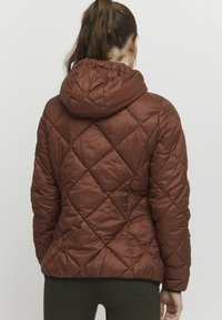 Doudoune marron avec un motif en losange matelassé, dotée d'une capuche et d'un tissu lisse et brillant. L'ourlet et les poignets sont élastiques pour un ajustement confortable.