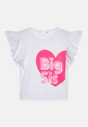 T-shirt blanc à manches courtes avec des manches volantées et un grand motif de cœur rose comportant le texte "Grande Sœur" en sequins.