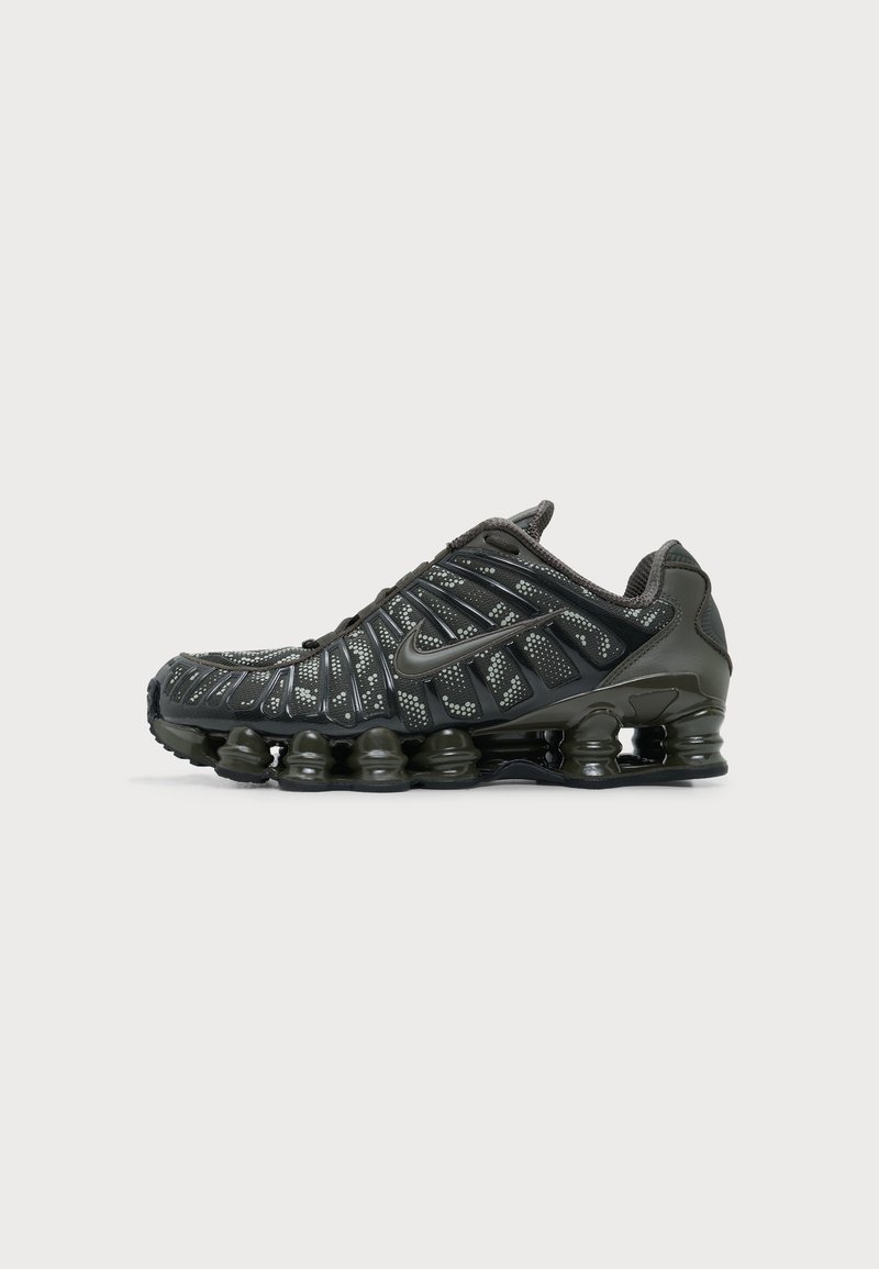 Μαύρο παπούτσι για τρέξιμο Nike με διαμερισματική απορρόφηση στο πέλμα και λευκό πουά σχέδιο στο επάνω ύφασμα, εμφανιζόμενο από την εξωτερική πλευρά.