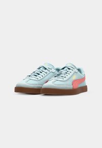 Jasnoniebieskie zamszowe sneakersy z różowymi akcentami, brązową gumową podeszwą i żółtym logo; mają sznurowanie i wszyte detale.