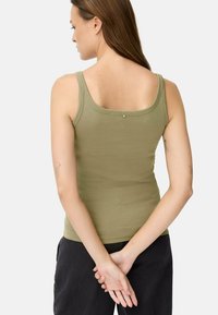 Olivgrünes Tanktop mit Rundhalsausschnitt und schmalen Trägern, das auf dem Rücken mit einem kleinen metallischen Akzent versehen ist. Glatter, enganliegender Stoff.
