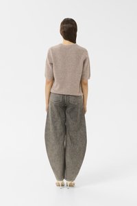 Figursydd taupe ullblandingsgenser med korte, pufferte ermer, iført sammen med oversized grå denim jeans med høy midje og synlige baklommer.
