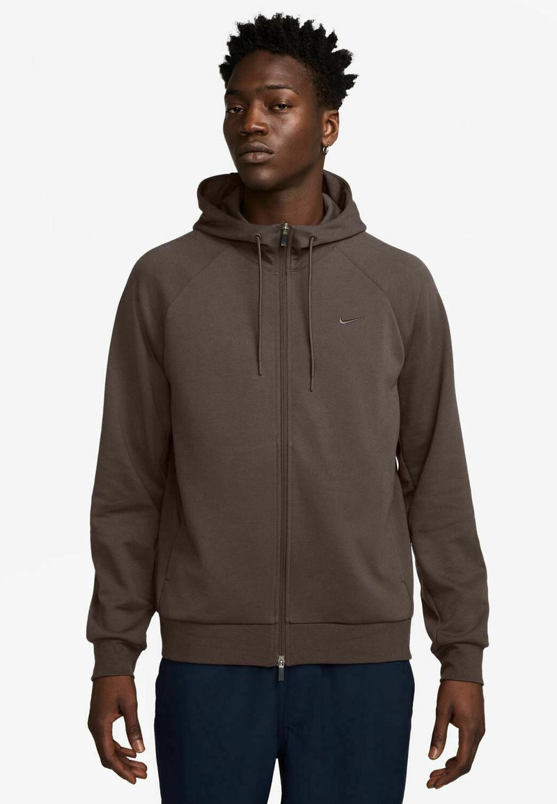 Brown zip-up hoodie with a drawstring hood, raglan sleeves, and embroidered logo on the chest. Smooth texture and fitted cuffs.