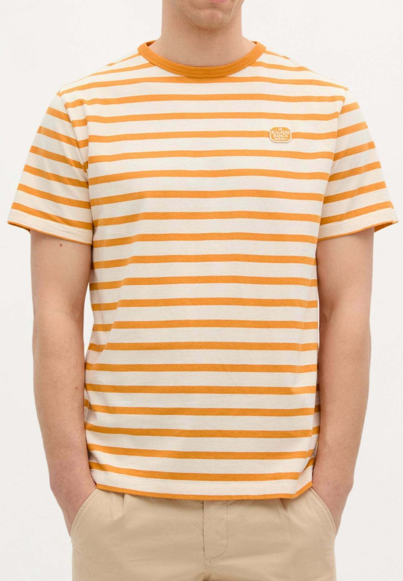Camiseta a rayas con franjas horizontales naranjas y blancas. Cuello redondo, material de algodón suave, parche de logo en el pecho, corte relajado.