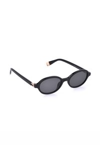 Lunettes de soleil ovales noires avec verres foncés et branches fines noires soulignées par de petits détails en or rose.