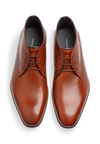 Bruine leren dresschoenen met een gladde afwerking, een spitse neus en een klassieke vetersluiting met gestikte details.