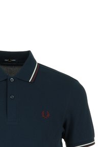 Polo di colore blu navy con colletto a costine caratterizzato da strisce bianche e bordeaux. Logo ricamato in rosso sul petto. Tessuto testurizzato.