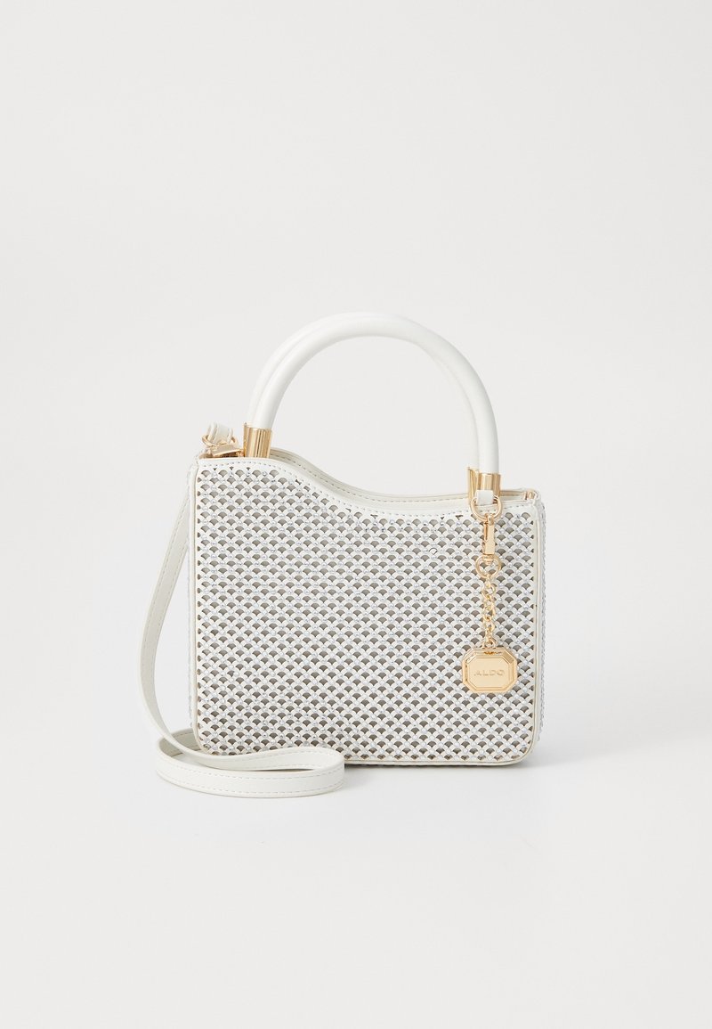 Sac à main blanc avec motif tissé texturé, poignée arrondie, longue bandoulière et breloque chaîne dorée sur un fond blanc uni.