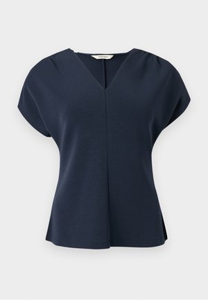 Donkerblauwe blouse met korte mouwen, V-hals, geplooide schouders en een lichte uitlopende zoom, weergegeven op een witte achtergrond.