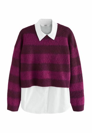 Gekürzter Pullover im gestreiften Design in Dunkellila und Fuchsia, aus einem flauschigen Material. Unterhalb trägt er ein weißes Hemd mit Kragen.