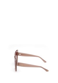 Lunettes de soleil transparentes marron avec une monture carrée et des bords légèrement arrondis. Dotées de branches fines avec un détail du logo doré.