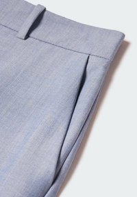 Pantalon bleu clair à texture lisse, avec un pli frontal et une ceinture plate, souligné par des détails de couture soignés.