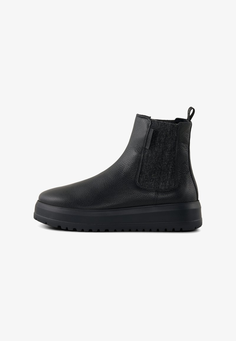 Bottes noires à la cheville en cuir texturé, avec panneaux latéraux élastiques et une semelle en caoutchouc épaisse. Elles sont dotées d'une languette pour un enfilage facile.
