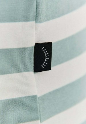 Pruhovaná tkanina s striedajúcimi sa svetlomodrými a bielymi farbami. Čierny štítok má biele línie naznačujúce riasy. Hladká textúra.