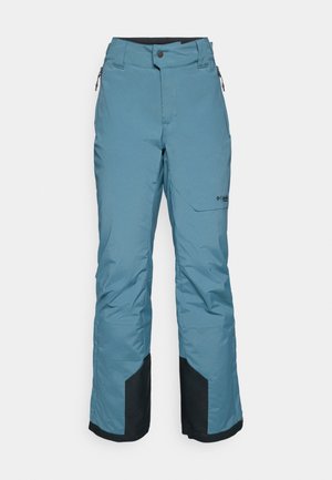 Calças de esqui azul claro com um corte descontraído, bolsos laterais e detalhes pretos na parte inferior para maior durabilidade e proteção.