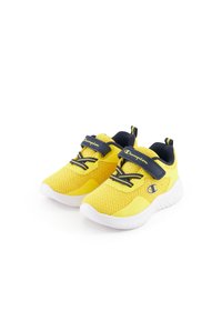 Zapatillas amarillas con una parte superior texturizada, acentos azules y una correa de Velcro. La suela blanca redondeada proporciona amortiguación y flexibilidad.
