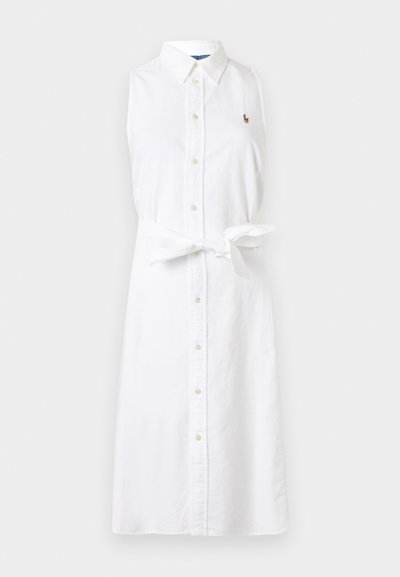 Ujjatlan fehér gombos ingruha gallérral, derékrészen megkötős övvel és kis hímzett logóval a bal mellrészen.