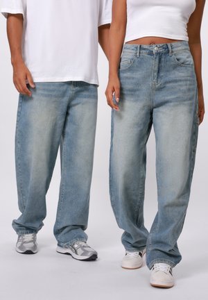 Light blue denim relaxed-fit jeans with a faded finish. Features five pockets, a front button closure, and visible stitching details.