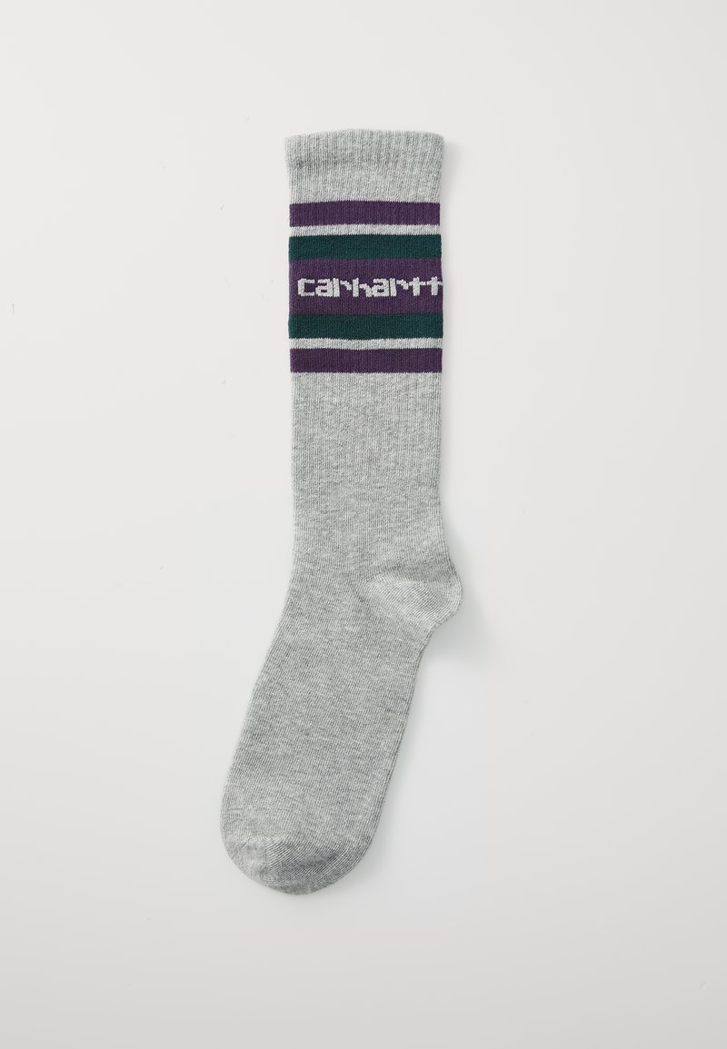 Šedá ponožka s žebrovaným manžetou, ktorá obsahuje páskový vzor v zelených, fialových a bielych farbách a centrálnym logom v bielej farbe.