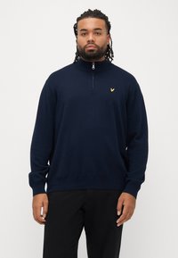 Maglione blu navy con cerniera e collo alto, realizzato in tessuto morbido. Presenta polsini a coste e un piccolo logo dorato sul petto.