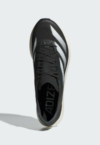 Schwarzer Sportschuh mit strukturiertem Mesh-Obermaterial, weißen Akzenten und flachem Schnürverschluss. Verfügt über eine gepolsterte Sohle für Komfort.