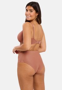 Ensemble soutien-gorge et culotte taille haute en rose poussiéreux. Matériau doux avec un motif géométrique sur les côtés. Bretelles réglables et détail de fermeture à crochet.