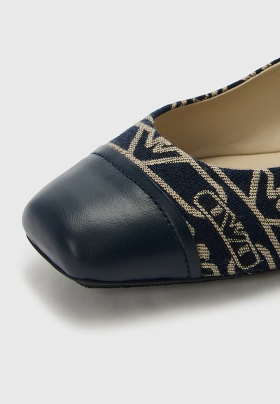 Pantofi fără toc de culoare bleumarin, cu o vârful din piele și un exterior din textil care prezintă un design cu modele bej, textură fină și formă rotunjită.