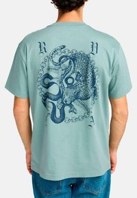 Short-sleeved, light teal t-shirt featuring a blue graphic of a leopard and snake within a chain pattern on the back.
