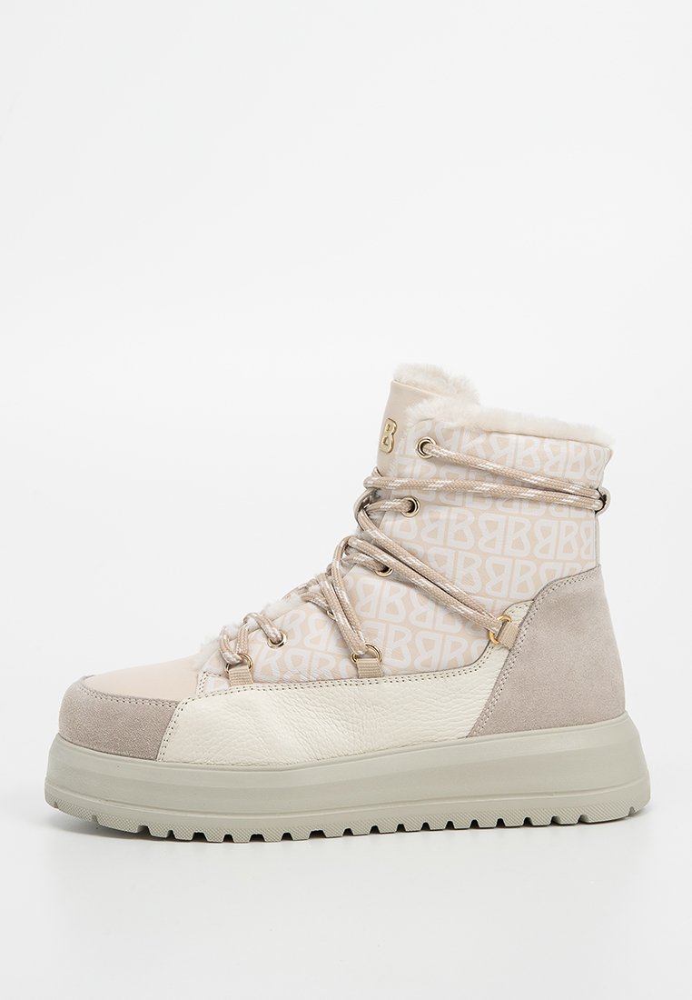 Teksturowany beżowy i kremowy but do wędrówek z futrzanym wykończeniem, wzorzystą cholewką i sznurowanym zapięciem. Gruba, amortyzująca podeszwa dla dodatkowego wsparcia.