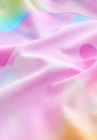 Un material moale, ușor, de culoare roz pastel, cu motive circulare subtile în lavandă și albastru, creând o textură netedă și fluidă.