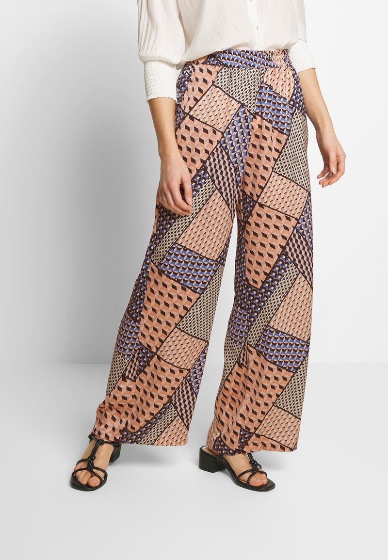 Kalhoty s širokými nohavicemi a geometrickým vzorem v odstínech broskvové, modré a černé; lehký materiál; elastický pas; sandály na blokovém podpatku.