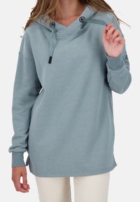 Valkoinen puuvillasekoitehuppari, jossa on V-pääntie, kiristettävä huppu ja resorit. Hupparissa on logo-yksityiskohta hihassa ja rento malli.