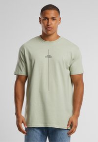 Light green, short-sleeve cotton t-shirt with a crew neck, featuring a central black text graphic that reads "think DIFFERENT."