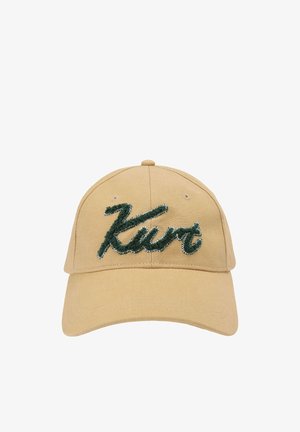 Casquette de baseball beige avec le script texturé "Kurt" en vert foncé brodé sur le panneau avant.