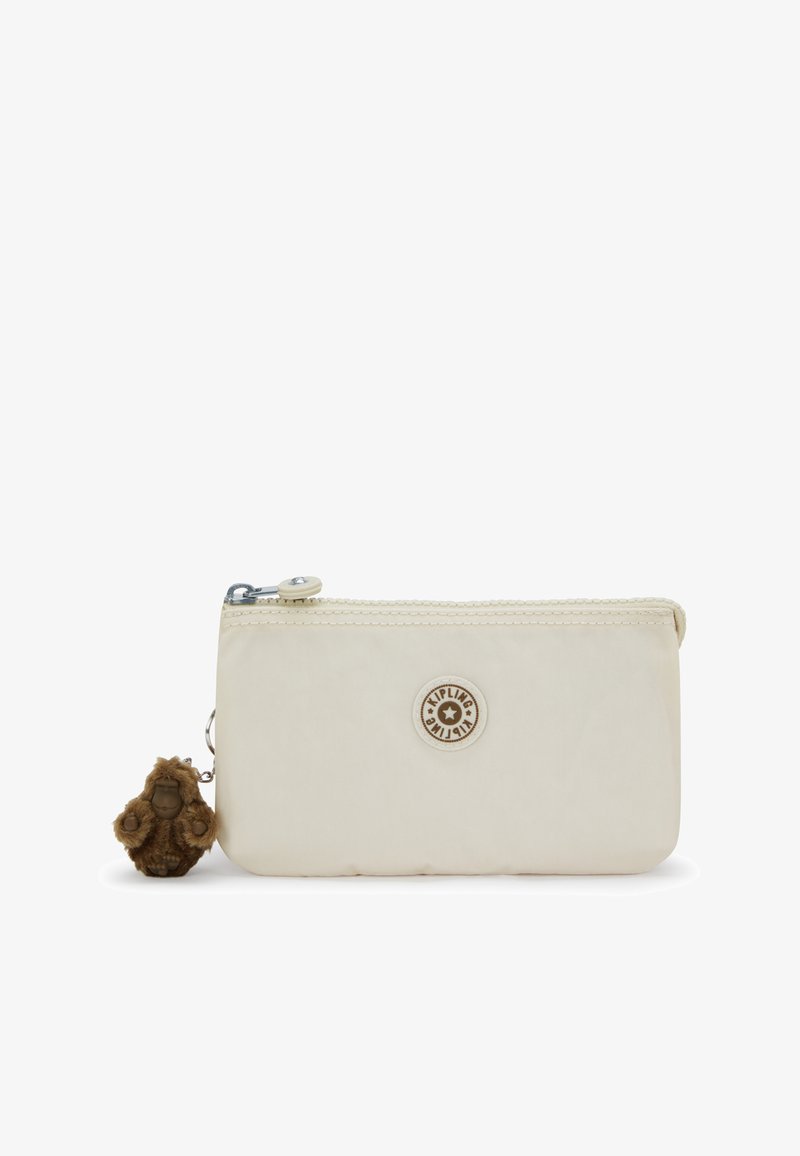 Pochette rectangulaire beige avec fermeture éclair, logo rond Kipling et petit porte-clés singe en peluche marron attaché à la tirette.