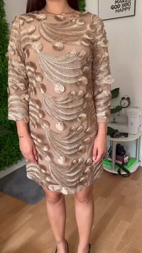 Beige dolgo-sleeve obleka z zapletenimi bež in kovinskimi vezeninami listnatih vzorcev. Prosojna tkanina z večplastnimi teksturami in ravnim krojem.