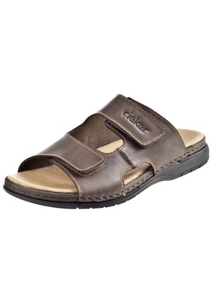 Sandale en cuir marron avec une sangle Velcro réglable, panneaux latéraux texturés, semelle rembourrée et semelle en caoutchouc durable. Marque Rieker visible.