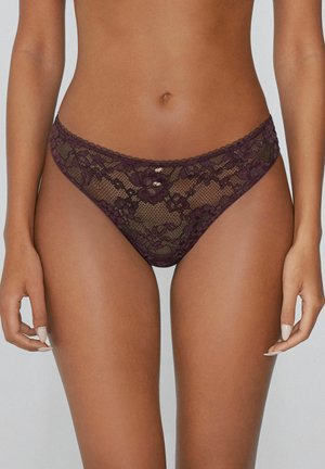 Tanga de encaje en burdeos profundo, con patrones florales y bordes festoneados, y pequeños acentos en tono dorado en la cinturilla.