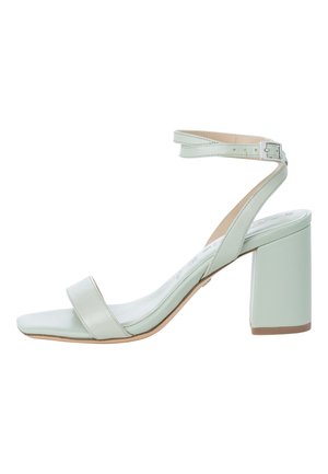 Lysegrøn sandal med blokhæl, åben tå, ankelrem og spænde, vist på hvid baggrund.