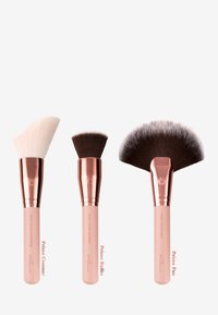 Tre pennelli per il trucco: un pennello angolato per il contouring bianco, un pennello buffer marrone e un pennello a ventaglio. Tutti hanno ferrule in oro rosa e manici rosa chiaro.