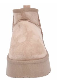 Stivaletti alla caviglia in suede beige con punta rotonda, superficie testurizzata e suola piatta spessa. Presentano un'apertura elasticizzata per una facile calzata.